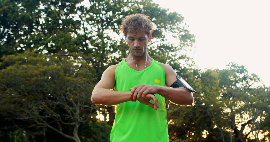 Man Adjusting Smartphone on Armband During Outdoor Workout - Free Images, Stock Photos and Pictures on Pikwizard.com