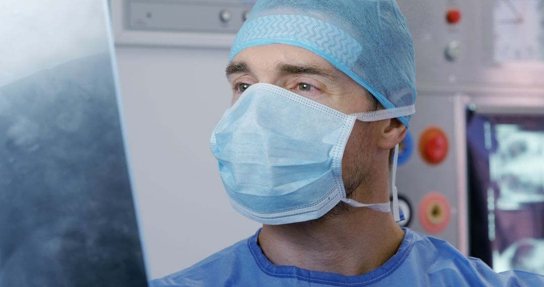 Caucasian Surgeon Intently Examining X-Ray in Modern Hospital - Free Images, Stock Photos and Pictures on Pikwizard.com