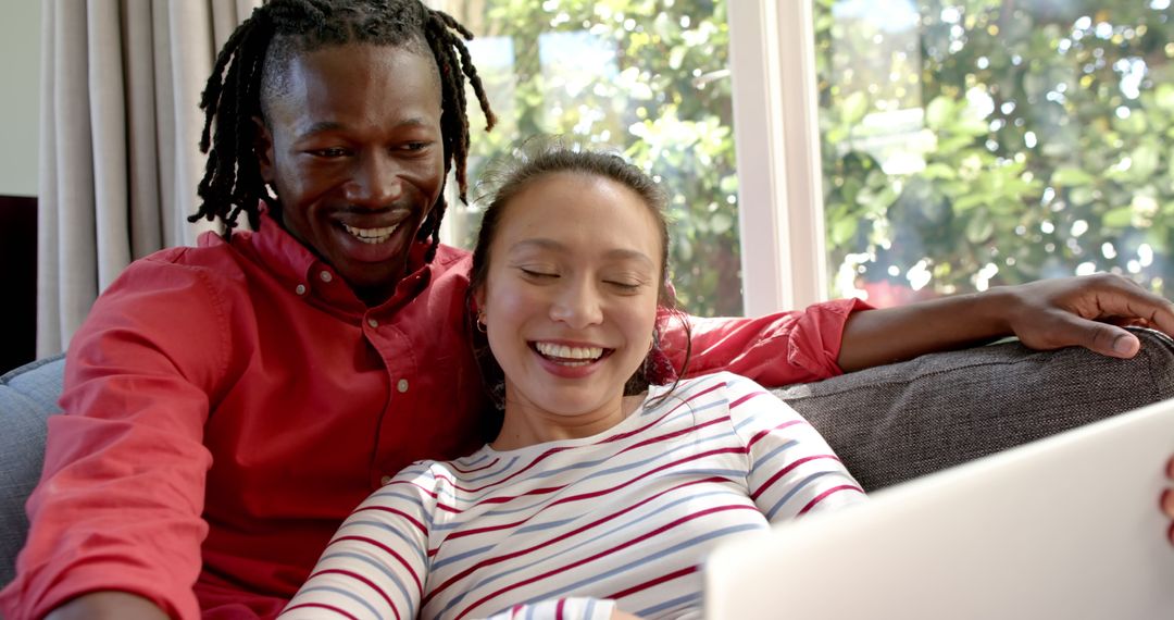 Happy Couple Relaxing Together Using Laptop at Home