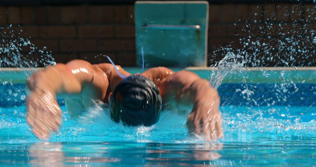 Male Swimmer Competing Butterfly Stroke in Outdoor Pool - Free Images, Stock Photos and Pictures on Pikwizard.com