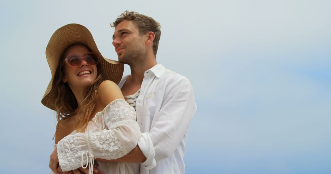 Joyful Couple Embracing on Beach Enjoying Vacation