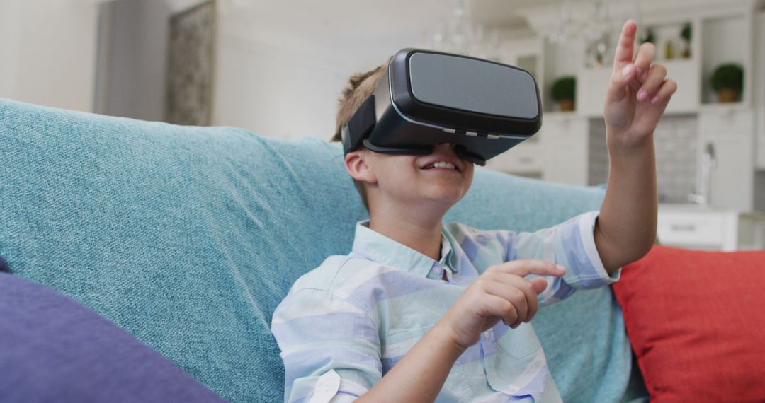 Excited Boy Playing with Virtual Reality Headset at Home on Couch - Free Images, Stock Photos and Pictures on Pikwizard.com