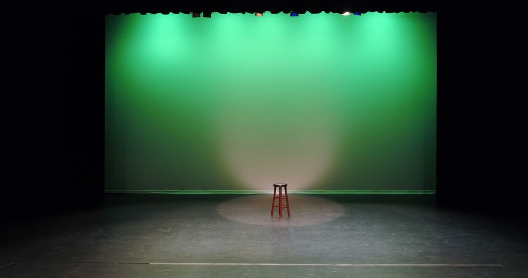 An empty stage with a single red chair under a spotlight, with copy space - Free Images, Stock Photos and Pictures on Pikwizard.com