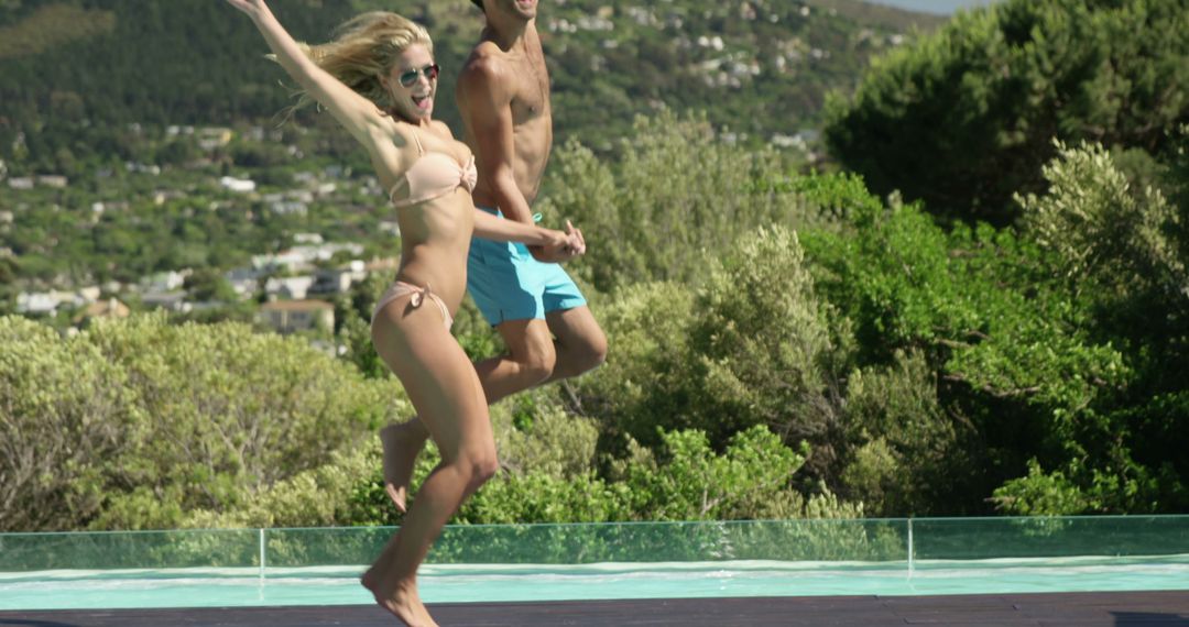 Energetic Couple Jumping into Pool Under Bright Sun - Free Images, Stock Photos and Pictures on Pikwizard.com