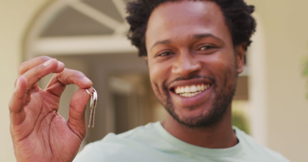 Smiling Man Holding Keys Symbolizing Home Ownership