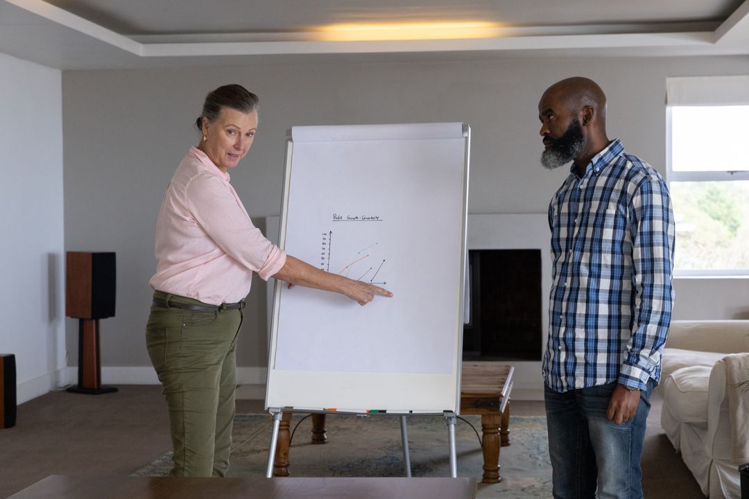 Diverse Senior Colleagues Discussing Line Graph in Modern Living Room