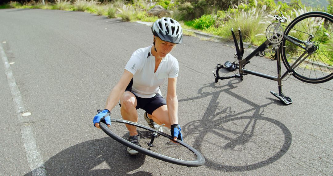 Cyclist fixing flat tire on road while on cycling trip - Free Images, Stock Photos and Pictures on Pikwizard.com