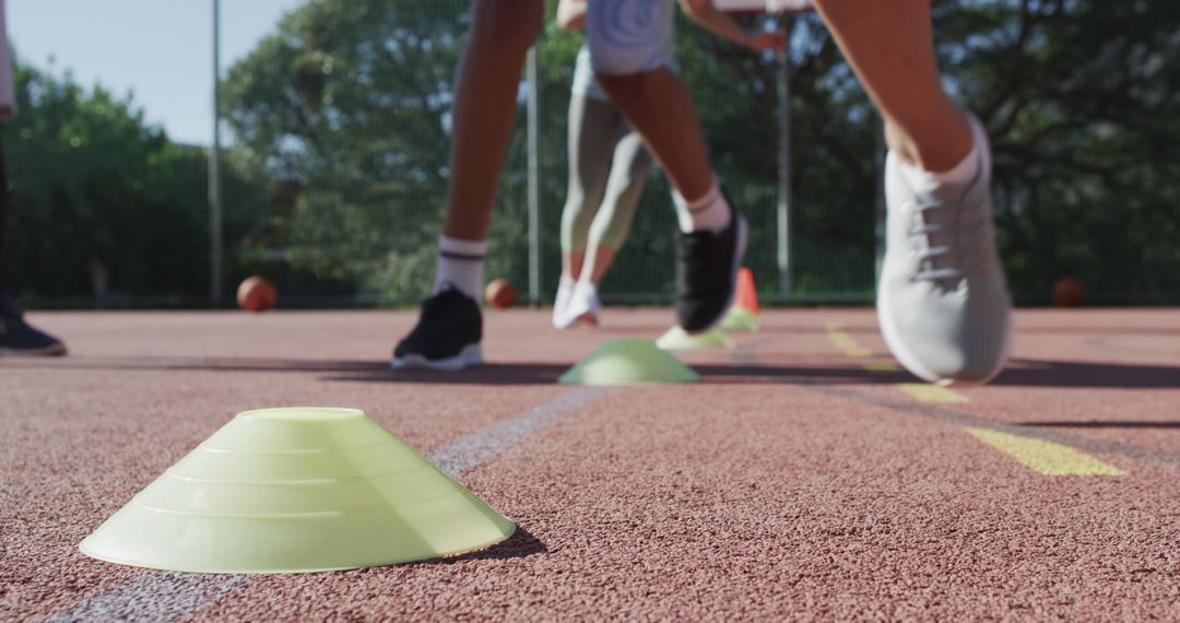 Group of Athletes Training Outdoors with Cones on Track - Free Images, Stock Photos and Pictures on Pikwizard.com