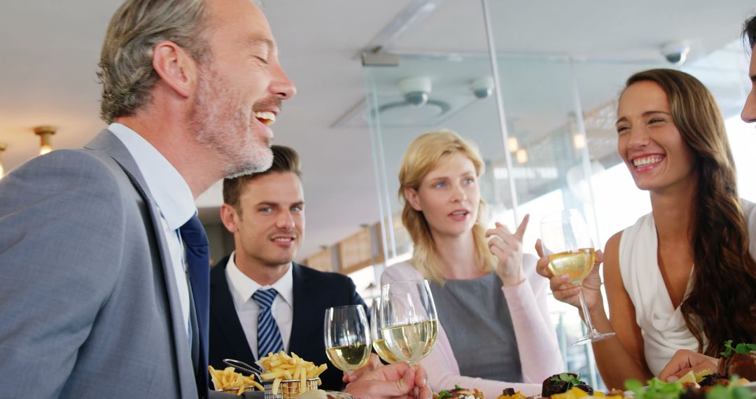 Business Colleagues Dining and Sharing Laughter in Modern Restaurant