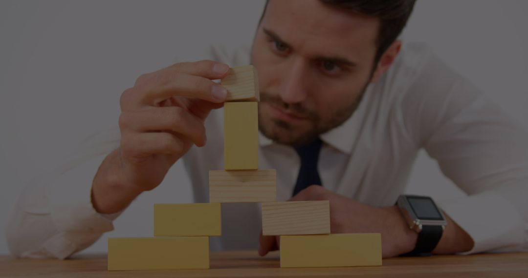 Focused Man in Formal Attire Building Block Tower