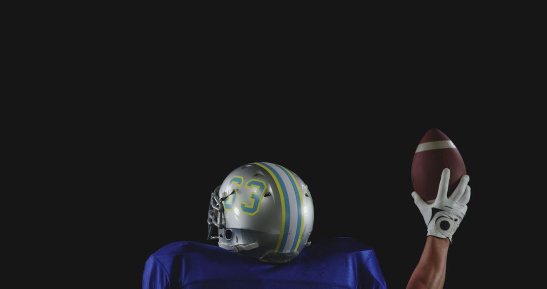 Football Player Ready to Throw Ball Against Black Background - Free Images, Stock Photos and Pictures on Pikwizard.com