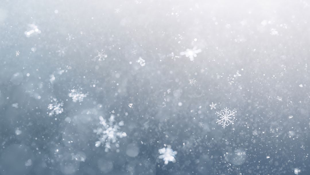 Glinting hexagonal snowflake falling through frosty bokeh winter air with crystal macro