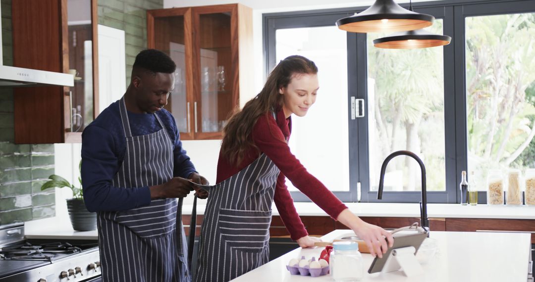 Couple Using Tablet while Cooking Together in Modern Kitchen