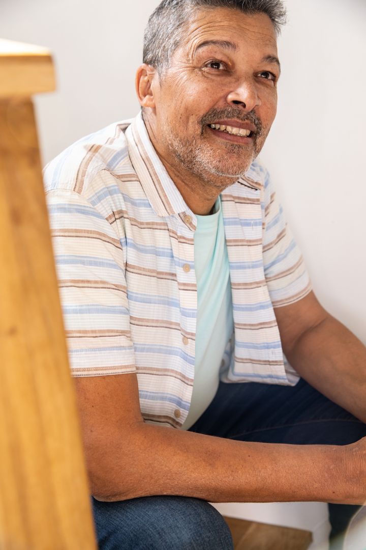 Senior Man Relaxed at Home Sitting on Wooden Ladder