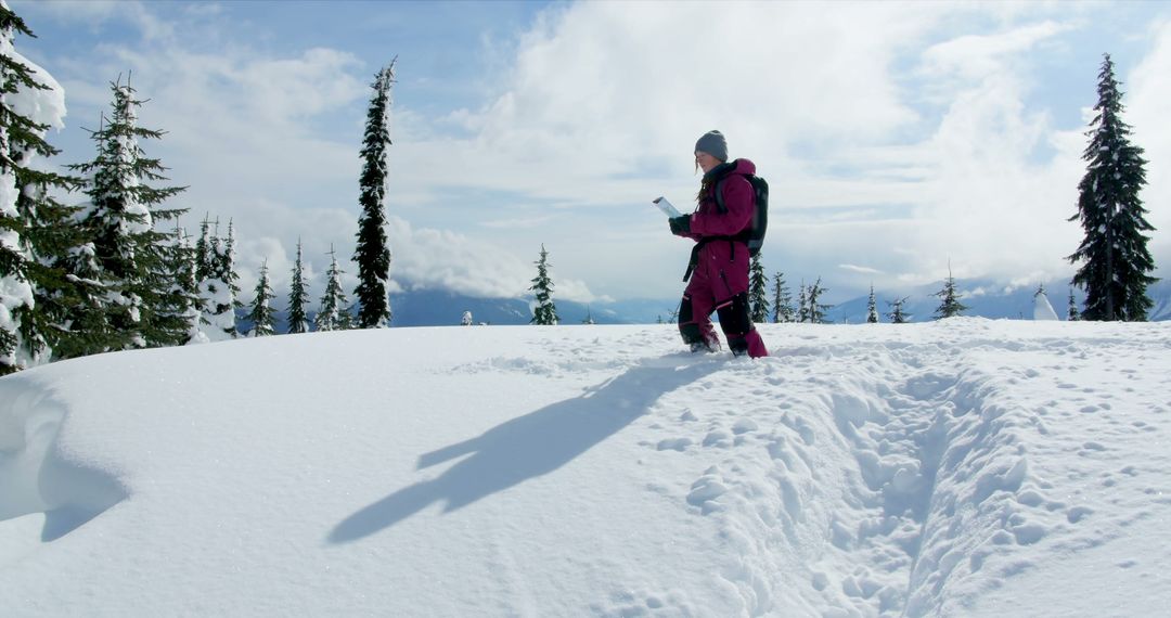 Person Reading Book Standing in Snow-Covered Mountain Landscape - Free Images, Stock Photos and Pictures on Pikwizard.com