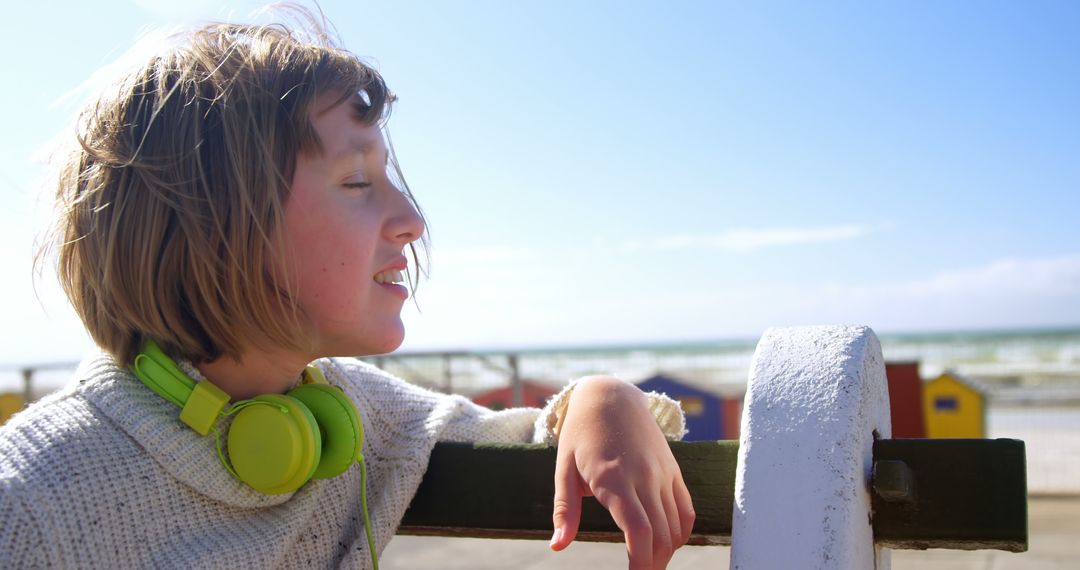 Smiling Young Girl with Headphones Relaxing by Seaside - Free Images, Stock Photos and Pictures on Pikwizard.com