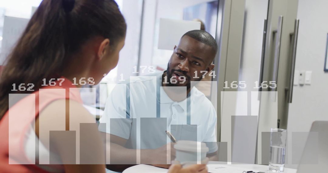 Coworkers Discussing Project Data with Chart Overlay in Office