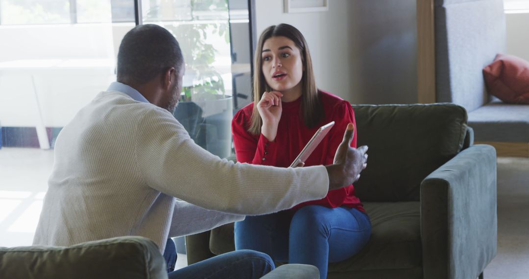 Diverse Team Engaging in Serious Discussion at Home Lounge