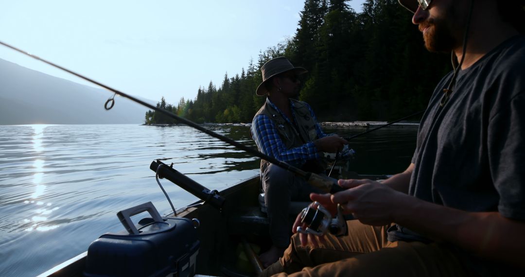 Two Men Fishing on Tranquil Lake Surrounded by Forest - Free Images, Stock Photos and Pictures on Pikwizard.com