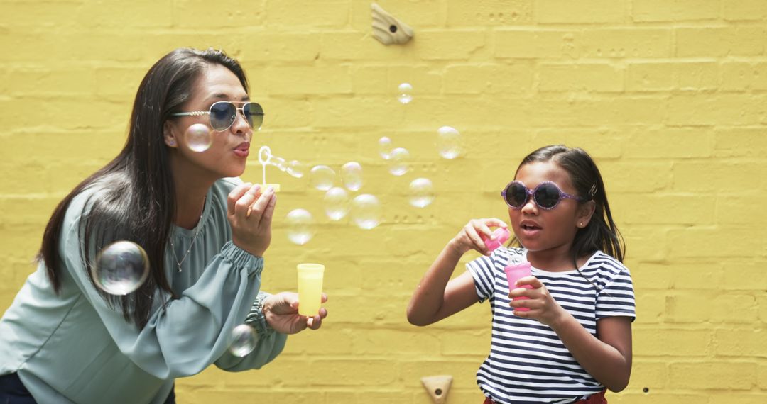 Mother and Daughter Blowing Bubbles on Sunny Day