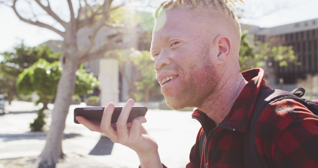 Young Albino Man Using Voice Command on Smartphone Outdoors - Free Images, Stock Photos and Pictures on Pikwizard.com