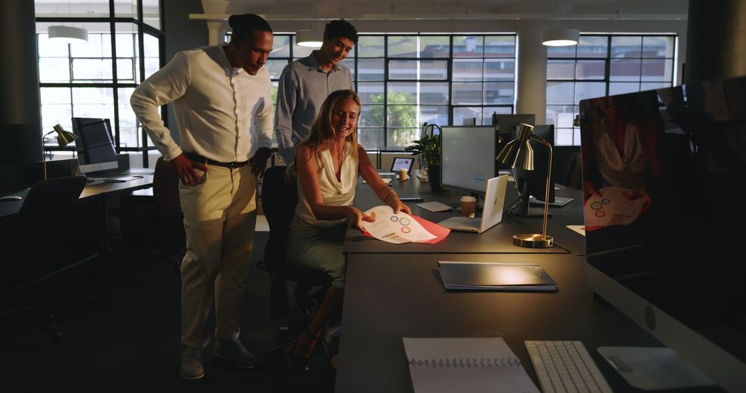 Diverse Team Collaborating on Project in Modern Office at Night