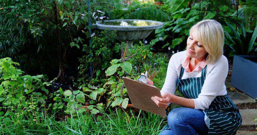 Female Botanist Recording Observations in Lush Garden - Free Images, Stock Photos and Pictures on Pikwizard.com