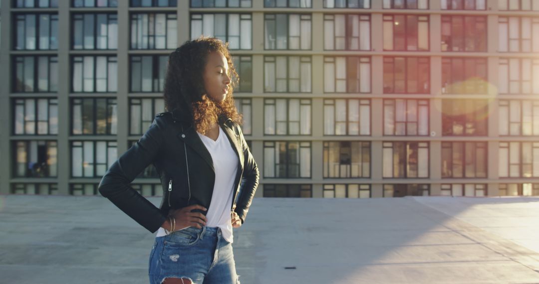 Confident Young Woman Standing on Rooftop at Sunset - Free Images, Stock Photos and Pictures on Pikwizard.com