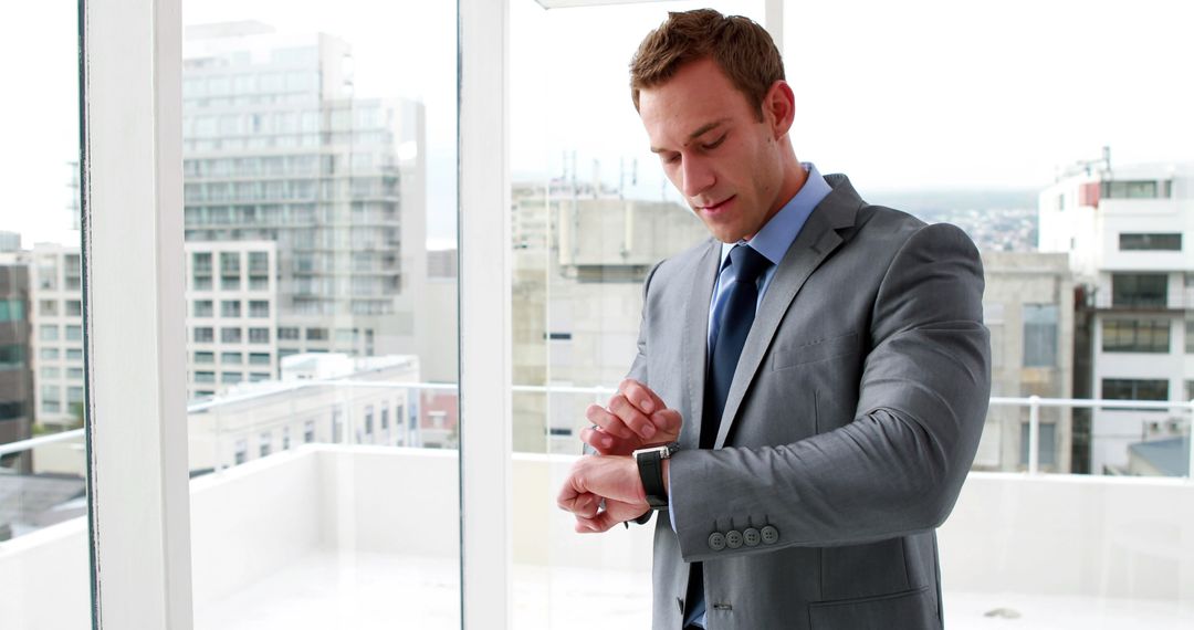 Businessman checking smartwatch in modern office - Free Images, Stock Photos and Pictures on Pikwizard.com