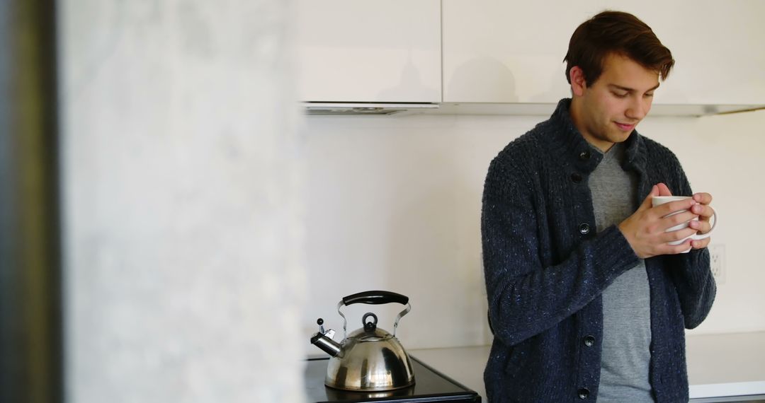 Man Enjoying Hot Beverage in Minimalist Kitchen - Free Images, Stock Photos and Pictures on Pikwizard.com