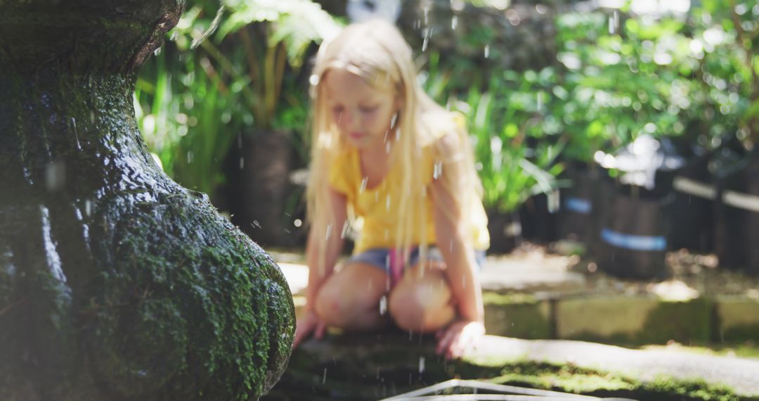 Girl in Sunny Garden Exploring Pond by Stone Fountain - Free Images, Stock Photos and Pictures on Pikwizard.com