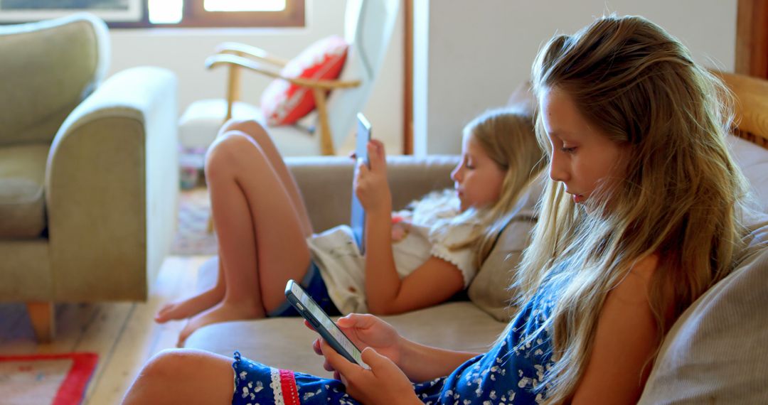 Two Girls Using Smartphones on Couch at Home - Free Images, Stock Photos and Pictures on Pikwizard.com