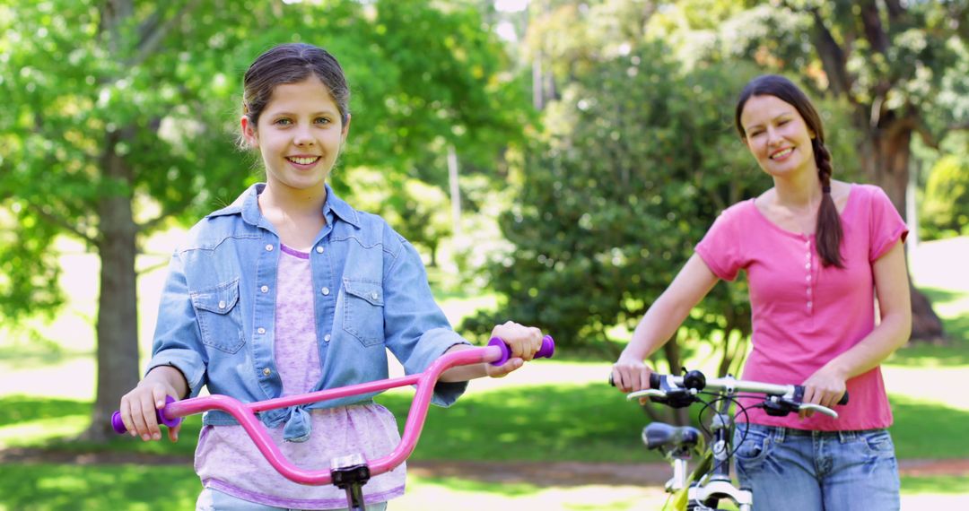 Mother and Daughter Biking Together in Park on Sunny Day - Free Images, Stock Photos and Pictures on Pikwizard.com