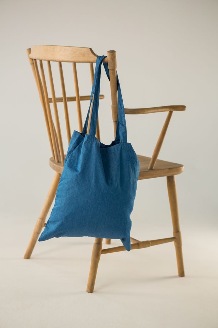 Blue bag hanging on a wooden chair - Free Images, Stock Photos and Pictures on Pikwizard.com