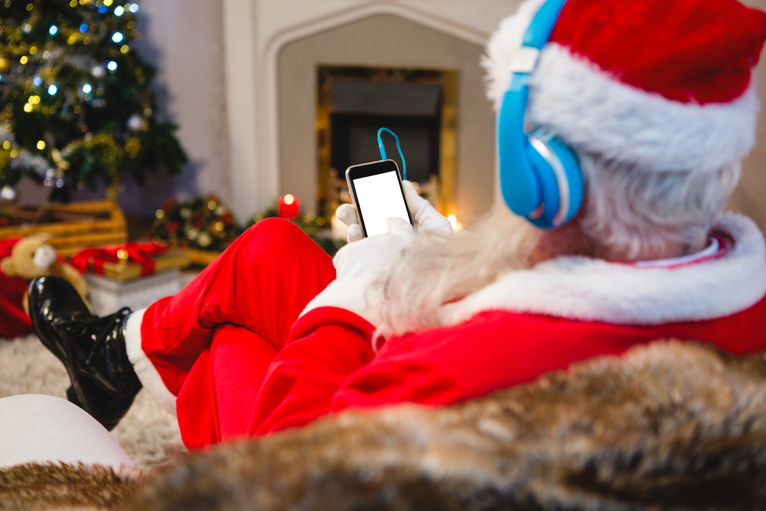 Santa Claus using digital tablet with blue headphones during Christmas time - Download Free Stock Images Pikwizard.com