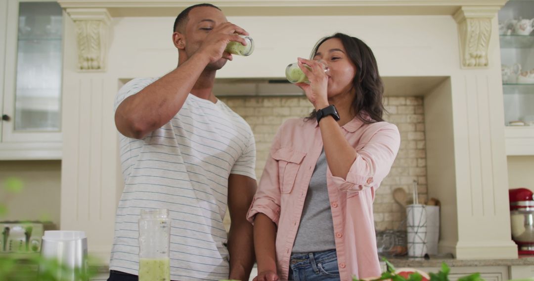 Smiling Couple Enjoying Homemade Smoothies in Kitchen