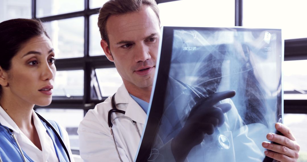 Two doctors of diverse ethnicities scrutinize an X-ray, indicating a critical medical analysis. - Free Images, Stock Photos and Pictures on Pikwizard.com