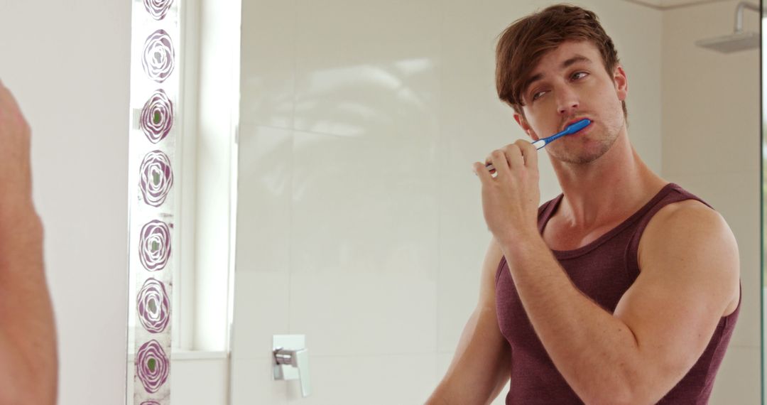 Young Man Brushing Teeth in Bathroom Mirror - Free Images, Stock Photos and Pictures on Pikwizard.com