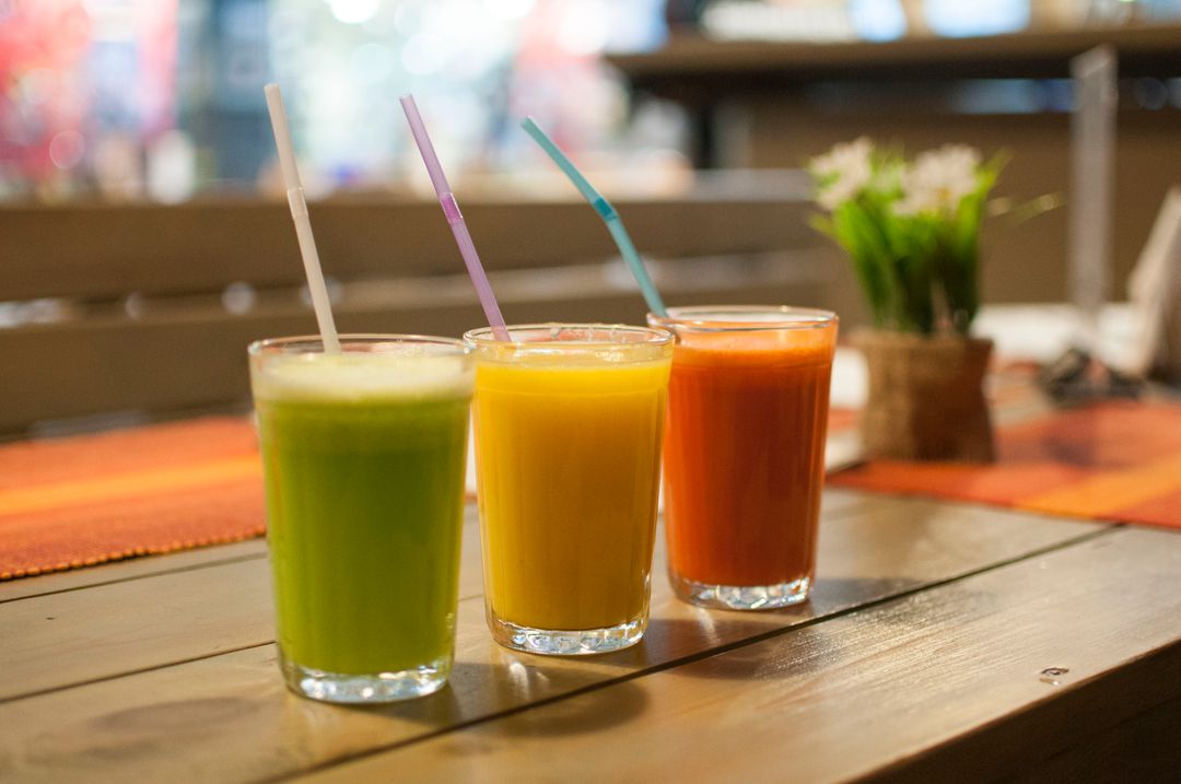 Vibrant Fresh Juice Trio on Wooden Table - Free Images, Stock Photos and Pictures on Pikwizard.com