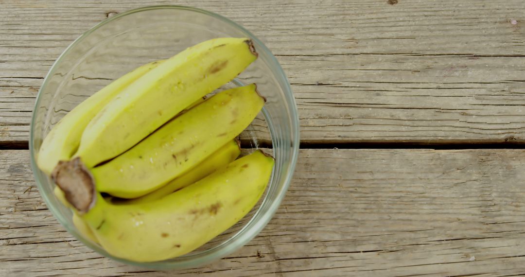 A bowl of ripe bananas sits on a rustic wooden surface, with copy space - Free Images, Stock Photos and Pictures on Pikwizard.com