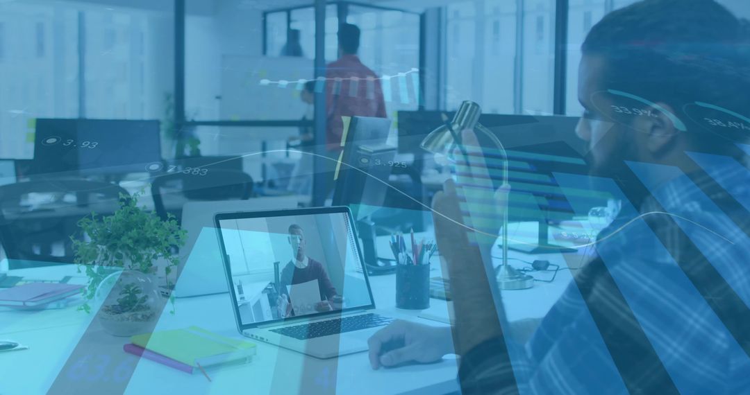 Man Drinking Water While Video Conferencing in Open-Plan Office