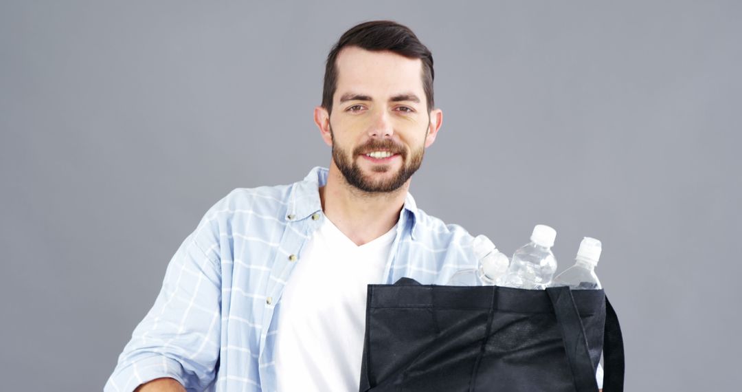 Young Man Holding Recycling Bag with Plastic Bottles Smiling - Free Images, Stock Photos and Pictures on Pikwizard.com