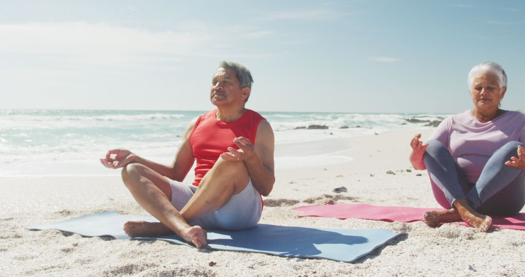 Elder Hispanic Couple Practicing Yoga on Beachfront