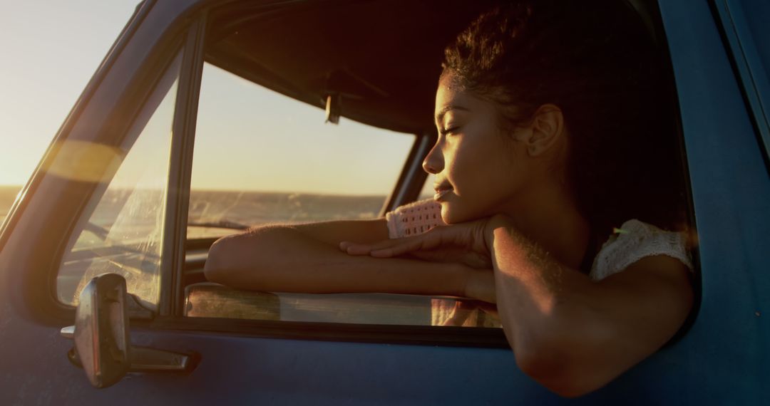 Woman enjoying serene sunset in parked truck - Free Images, Stock Photos and Pictures on Pikwizard.com