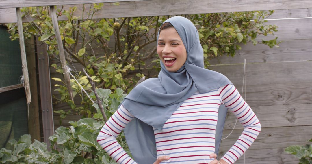 Smiling Woman in Hijab Standing in a Garden - Free Images, Stock Photos and Pictures on Pikwizard.com