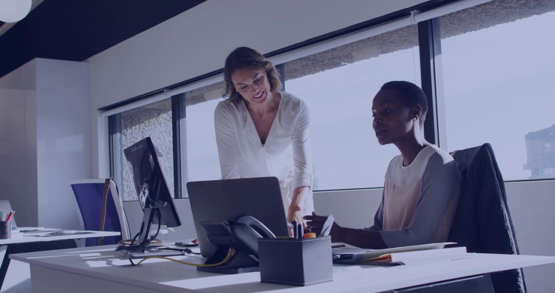 Manager Guiding Colleague Using Laptop in Bright Modern Office Workspace