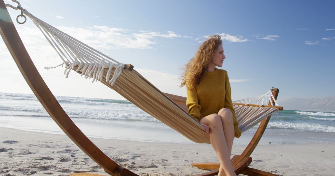A young Caucasian woman relaxes in a hammock on a sunny beach, with copy space - Free Images, Stock Photos and Pictures on Pikwizard.com