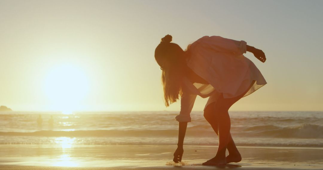 Woman Collecting Seashells on Beach at Sunset - Free Images, Stock Photos and Pictures on Pikwizard.com