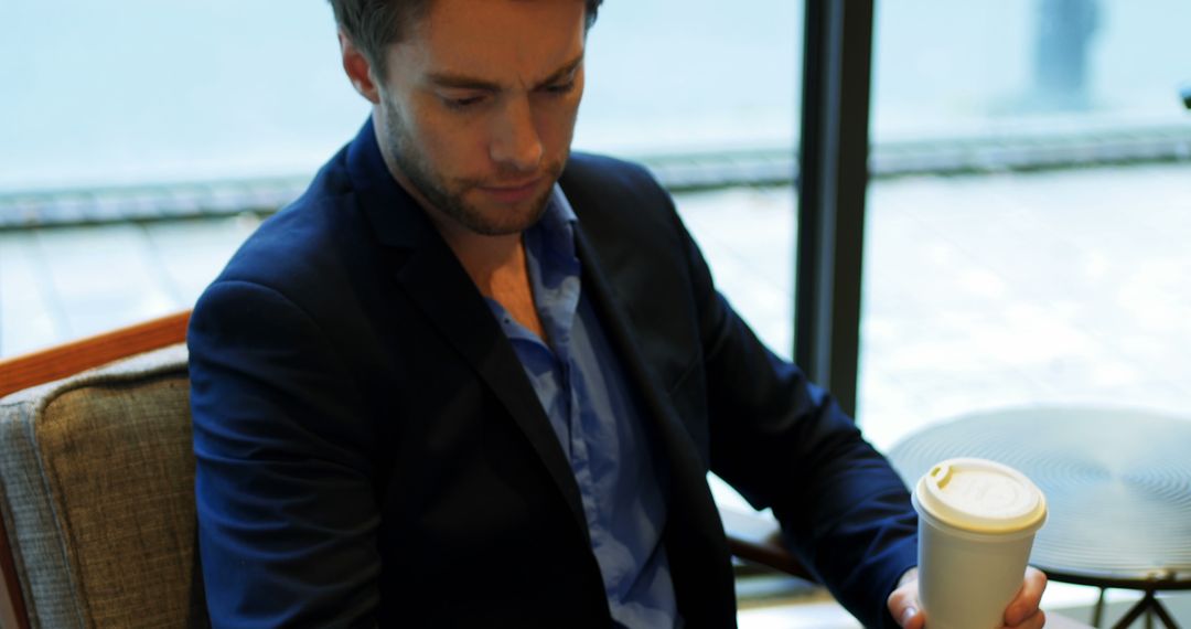 Thoughtful Businessman Holding Coffee Cup in Modern Office - Free Images, Stock Photos and Pictures on Pikwizard.com