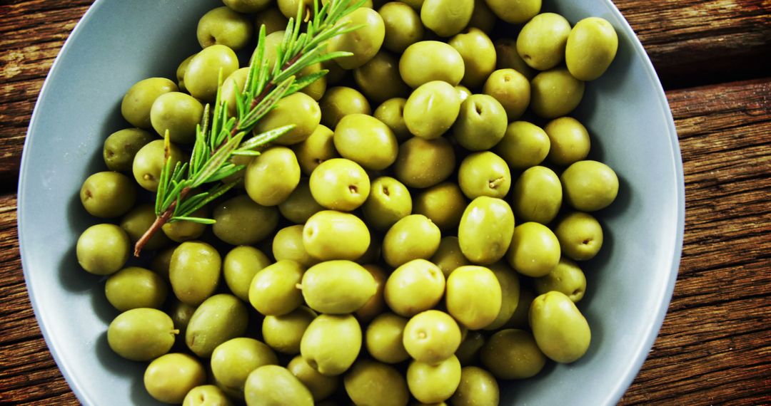 Close-up of Fresh Green Olives in Bowl with Rosemary Garnish - Free Images, Stock Photos and Pictures on Pikwizard.com